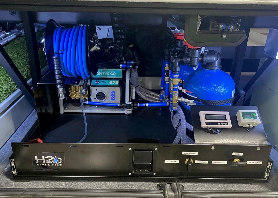 H2O Simplified installed wash equipment showing the blue hose reel, pressure washer and treatment plumbing without the wash kit in front